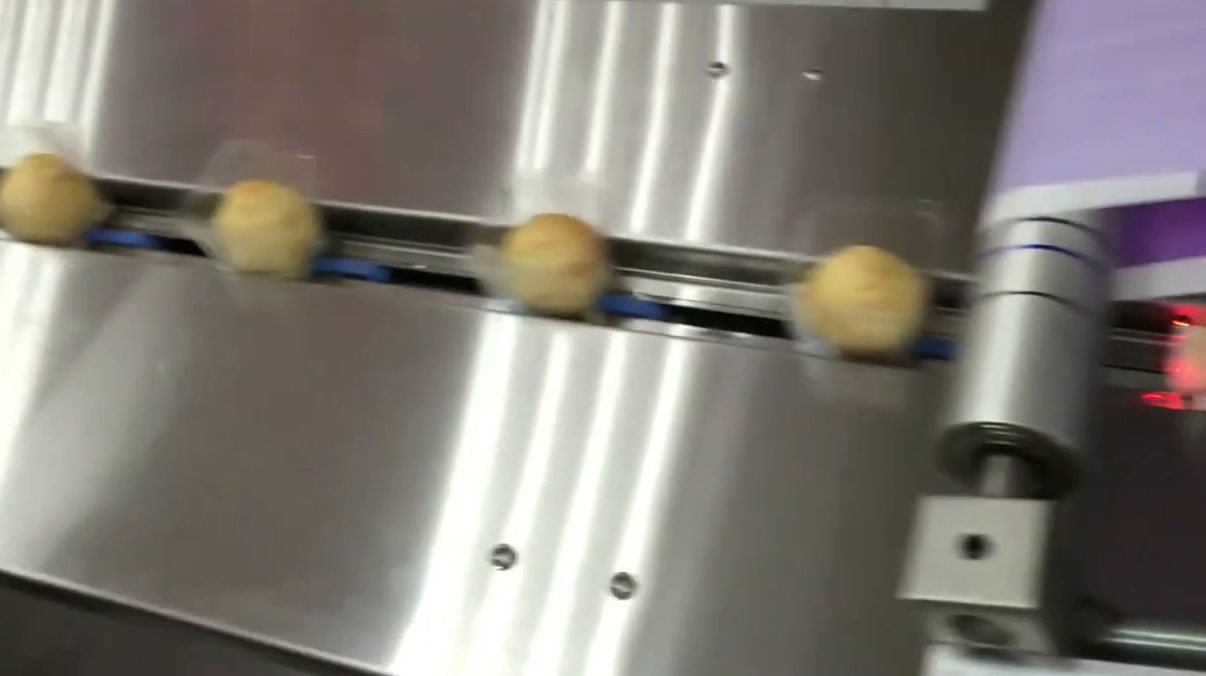 蛋黃酥連托盤一顆一顆進入臥式包裝機